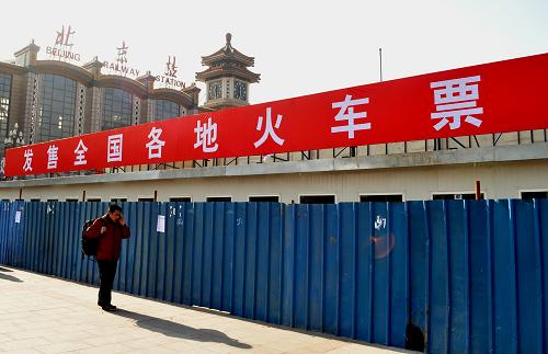 1月9日,一位旅客從北京站廣場搭建中的臨時售票處前經(jīng)過。新華社發(fā)(賀燦鈴 攝)