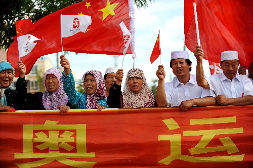 6月30日,當(dāng)?shù)馗髯迦罕姙榛鹁鎮(zhèn)鬟f加油。當(dāng)日,北京奧運圣火在寧夏吳忠傳遞。 新華社記者 王鵬 攝
