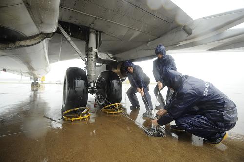 9月29日,在??谑忻捞m機(jī)場(chǎng),工作人員固定未離港飛機(jī)為臺(tái)風(fēng)“納沙”登陸做準(zhǔn)備。新華社發(fā)(徐勤濤 攝)