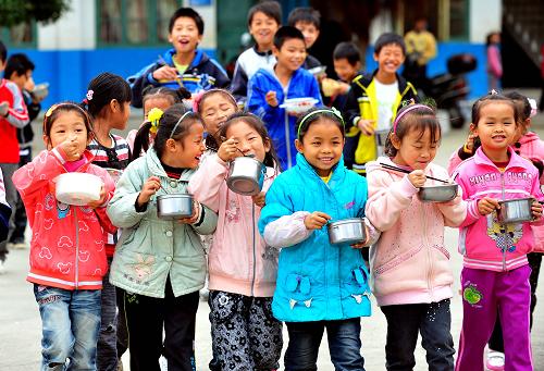 在廣西柳州市融安縣大良鎮(zhèn)中心小學(xué),學(xué)生們在吃免費午餐。柳州市從2008年秋季學(xué)期開始實施“貧困縣農(nóng)村義務(wù)教育階段學(xué)生實施免費午餐制度”(2011年11月9日攝)。廣西29個縣列入國家中小學(xué)營養(yǎng)改善試點,惠及110萬學(xué)生。2011年秋季學(xué)期,我國決定啟動實施農(nóng)村義務(wù)教育學(xué)生營養(yǎng)改善計劃,按照計劃初步方案,國家將在集中連片特殊困難地區(qū)啟動國家營養(yǎng)改善試點,每生每天補助3元,全年按在校250天計算。據(jù)了解,在國家實施營養(yǎng)改善計劃之前,廣西已有8個市在所轄的25個縣區(qū)中開展了營養(yǎng)改善試點工作,在“吃、建、管、教”等方面多管齊下,積極開展農(nóng)村義務(wù)教育學(xué)校學(xué)生營養(yǎng)改善試點工作,逐步解決農(nóng)村學(xué)生“吃飯難”問題,改善農(nóng)村學(xué)生營養(yǎng)狀況。