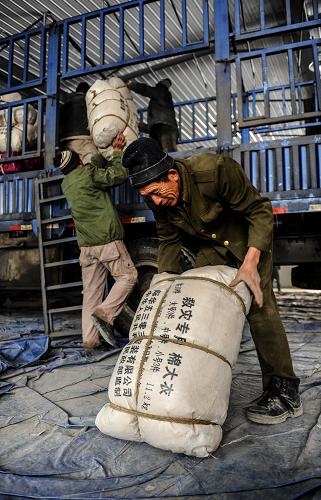 11月23日,工作人員在長春市救災(zāi)物資儲備中心搬運(yùn)救災(zāi)物資。新華社記者 許暢 攝