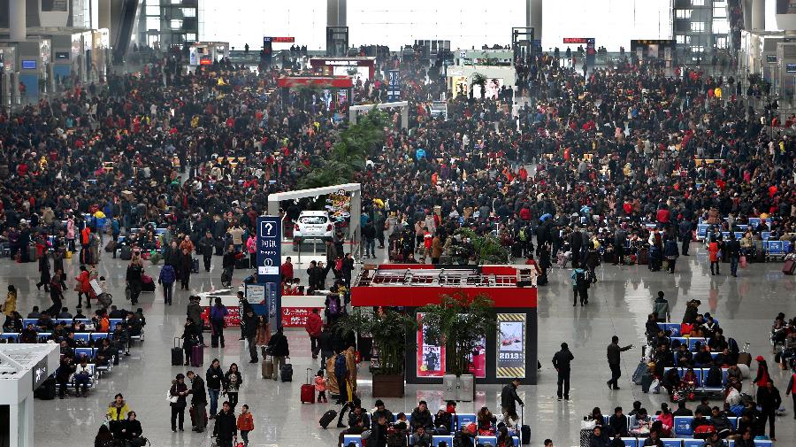 1月26日,旅客們?cè)谏虾:鐦蚧疖?chē)站候車(chē)大廳候車(chē)。新華社記者 凡軍 攝