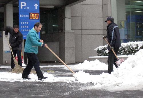 11月10日,北京降下今年第二場雪,市民們紛紛出動,清除道路上和門前的積雪。新華社記者 陳樹根 攝