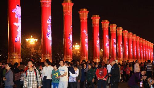 10月6日晚,游人在北京天安門廣場(chǎng)游覽。自10月2日以來,國(guó)慶60周年慶?;顒?dòng)的主要舉辦地北京天安門廣場(chǎng)游人如織。60輛游行彩車,直徑40米、高14.9米的“普天同慶”巨型花籃花壇吸引著全國(guó)各地的游客前來賞花車、拍美景,重溫國(guó)慶慶?;顒?dòng)的歡樂和激情。新華社記者 李明放 攝