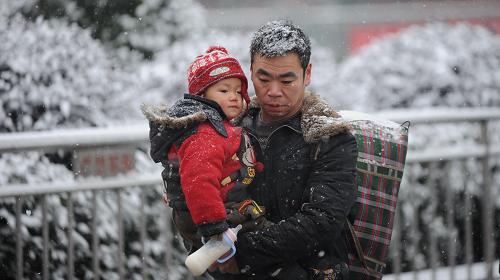 1月19日,南昌火車站,一位男子抱著孩子、身背行李在風(fēng)雪中趕往候車大廳。 當(dāng)日,2011年鐵路春運(yùn)正式啟動(dòng)。2011年鐵路春運(yùn)自2011年1月19日起至2月27日止,為期40天。春運(yùn)期間,全國鐵路預(yù)計(jì)發(fā)送旅客2.3億人次,同比增加2554萬人次,增長12.5%,日均575萬人次。其中,發(fā)送直通旅客9200萬人次,同比增長11.6%。新華社記者 周密 攝