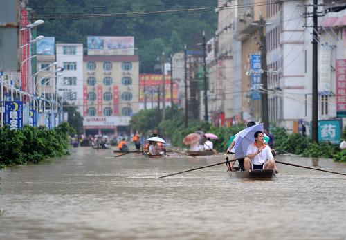 7月4日,在廣西融水瑤族自治縣縣城,多條街道進(jìn)水,小船成為最主要的交通工具。