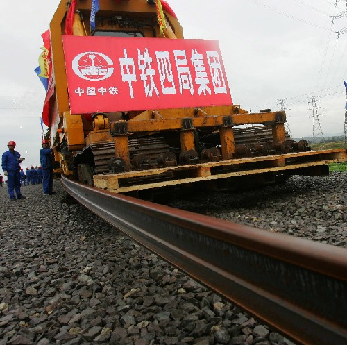 11月8日,在溫福、甬臺溫鐵路溫州段鋪軌現(xiàn)場,長軌條鋪軌機(jī)組鋪下第一根鐵軌。