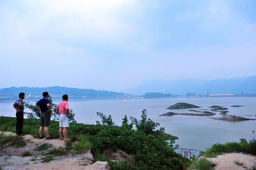 7月25日,市民在湖北省秭歸縣茅坪鎮(zhèn)木魚島遠眺水位上漲后的三峽水庫。 新華社發(fā)