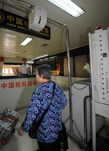 4月29日,一名入境旅客從紅外線體溫檢測(cè)儀前走過(guò)。 新華社記者 周文杰 攝