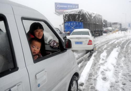 1月20日晨,在昌九高速路上,遭遇堵車的旅客向車窗外張望。1月19日下午開(kāi)始,暴雪突襲江西九江,積雪厚度超過(guò)12厘米,連接鄂贛皖三省的交通大動(dòng)脈——九江長(zhǎng)江大橋(公路橋)橋面出現(xiàn)結(jié)冰狀況,導(dǎo)致昌九高速?gòu)?9日22時(shí)起開(kāi)始堵車。截至20日清晨,暴雪仍在繼續(xù),從南昌到九江方向的車輛已滯留18公里。新華社記者 周科 攝