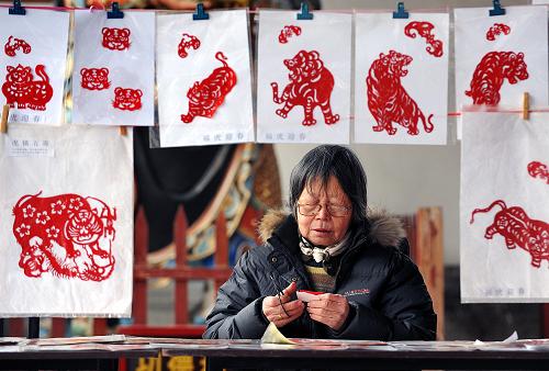 2月15日,在鄭州春節(jié)文化廟會上,一位民間藝人在現(xiàn)場制作老虎圖案的剪紙作品。春節(jié)期間,鄭州城隍廟舉辦了以民俗表演、民間工藝品展示為主要內(nèi)容的春節(jié)文化廟會,游客和市民在觀賞傳統(tǒng)“絕活兒”、選購民間“玩意兒”的同時增長民俗文化知識。新華社記者 王頌 攝