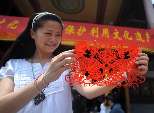 6月12日,一名市民在展示她在民間剪紙藝人指導(dǎo)下制作的剪紙。當(dāng)日是我國第五個(gè)“文化遺產(chǎn)日”。合肥市邀請(qǐng)10多名民間技藝傳承人在合肥城隍廟現(xiàn)場(chǎng)進(jìn)行手工面塑、葫蘆烙畫、民間剪紙、蛋雕等創(chuàng)作,向市民展示民間手工技藝,號(hào)召市民積極參與非物質(zhì)文化遺產(chǎn)的保護(hù)和傳承。新華社記者 劉軍喜 攝