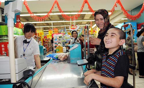 7月23日,市民在家樂福烏魯木齊大巴扎店購物。當(dāng)日,自烏魯木齊“7·5”事件后閉店17天的家樂福烏魯木齊大巴扎店重新開門營業(yè)。新華社記者 沙達提 攝