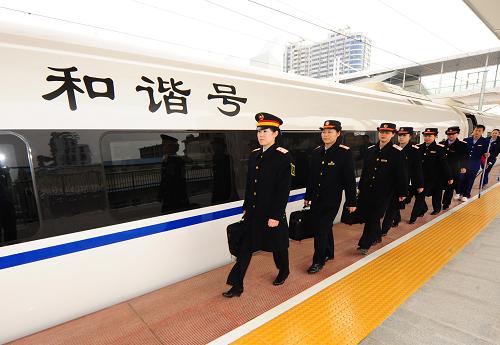 12月20日,武廣高鐵乘務(wù)員在廣州北站列隊(duì)上車。 新華社記者 程敏 攝