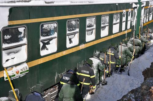 1月4日,消防戰(zhàn)士在內(nèi)蒙古商都受暴雪圍困的旅客列車邊除雪搶險(xiǎn)。新華社發(fā)(田瑜 攝)