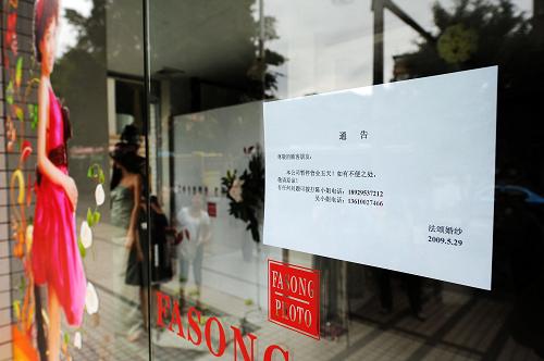 5月29日,二代病例患者工作的廣州市某婚紗影樓大門上張貼著暫時停業(yè)通告。 新華社記者 劉大偉 攝