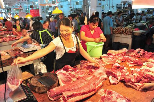 廣西南寧市民在菜市場里購買限價豬肉(2011年8月26日)。為遏制物價過快上漲,緩解老百姓特別是低收入群眾的生活壓力,廣西各市相繼對豬肉、大米、食用植物油、罐裝液化石油氣等4類商品實行臨時價格干預措施,并定點限量限價銷售。為確保干預措施的實施,自治區(qū)、市級財政對定點限量限價銷售商品進行補貼。新華社記者 黃孝邦 攝