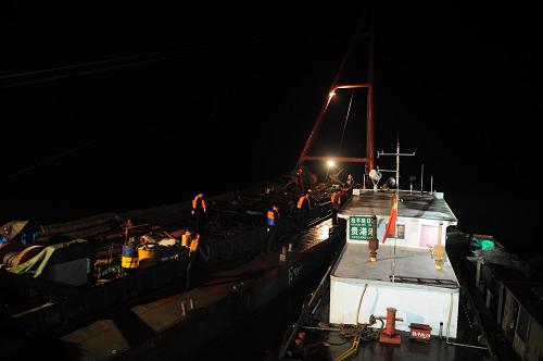 3月14日深夜,搜救人員在事發(fā)水域進行搜尋。貴港市政府3月15日下午發(fā)布桂平“3·11”水上交通事故處置工作最新進展,截止到當日中午,已找到事故沉船并打撈至岸邊,確認事故生還人數(shù)28人,死亡14人,失蹤6人。另據(jù)介紹,公安、交通、安監(jiān)等部門已對事故進行調(diào)查取證,分析事故發(fā)生原因,確定事故責(zé)任。3月13日,公安機關(guān)對客渡經(jīng)營人李達森、黃英信及貨船當班駕駛員李桂雄、船長陳漢超等4人依法進行刑事拘留。新華社記者 黃孝邦 攝