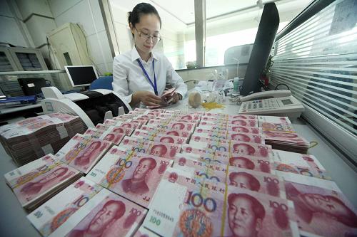 江蘇省贛榆縣農(nóng)村商業(yè)銀行營(yíng)業(yè)員在清點(diǎn)人民幣(2012年7月3日攝)。新華社發(fā)(司偉 攝)
