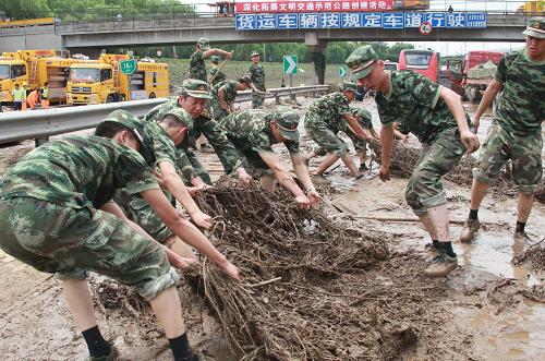 7月23日,參與救援工作的武警北京總隊(duì)某部官兵在進(jìn)行清理淤泥工作。新華社發(fā)(李光印 攝)