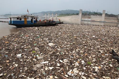 壩前堆積了大量的漂浮物(8月19日攝)。今年長江特大洪峰過后,洪水挾裹著從上游沖刷下來的垃圾、樹枝等漂浮物在三峽大壩前水域大量積聚,若不及時清除,不但污染長江水質(zhì),還會影響到三峽發(fā)電機組。8月以來,擔負三峽大壩守衛(wèi)任務的武警湖北總隊宜昌市支隊派出官兵,駕駛目前亞洲上最大的清漂船“清漂一號”,在壩前連續(xù)作業(yè),與目標單位清漂人員一起將大量漂浮物打撈上岸。 新華社發(fā)(李開勇 攝)