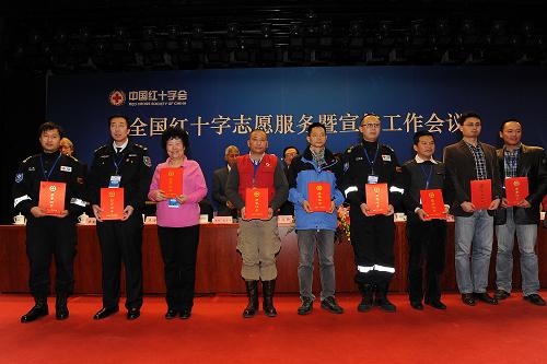 12月4日,榮獲“中國(guó)紅十字志愿服務(wù)專業(yè)貢獻(xiàn)獎(jiǎng)”的代表在臺(tái)上領(lǐng)獎(jiǎng)并合影。新華社記者 何俊昌 攝