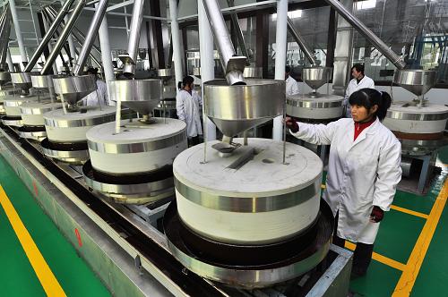 1月26日,返鄉(xiāng)民工在山東省濱州市鄒平縣臺子鎮(zhèn)香油加工廠照看石磨。新華社發(fā)(董乃德 攝)