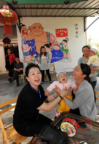 4月15日,綿竹市孝德鎮(zhèn)年畫村村民和前來考察的紅十字會代表(左)交流。新華社記者 何俊昌 攝