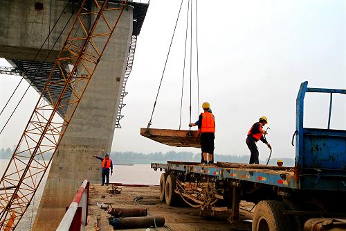 4月17日,施工人員在拆除湖北黃岡長江大橋主橋施工用的棧橋。新華社發(fā)