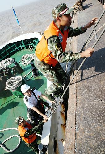7月24日,在浙江省嵊泗縣馬跡山港,聯(lián)合執(zhí)法人員登船檢查。新華社記者 徐昱 攝