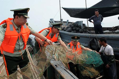 7月25日,青島海泊河邊防派出所警官在轄區(qū)海面查獲一條正在偷布“絕戶籠”的漁船。新華社記者 李紫恒 攝