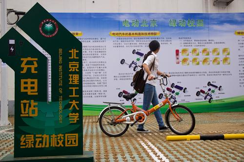 9月12日,一名學(xué)生從北京理工大學(xué)開(kāi)設(shè)的電動(dòng)汽車(chē)租賃站前走過(guò)。新華社發(fā)(賈亞男 攝)