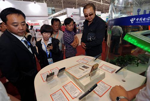 游客在亞歐博覽會(huì)中國(guó)電信展臺(tái)上挑選3G手機(jī)(9月3日攝)。新華社記者趙戈攝