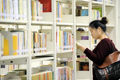一位市民在深圳圖書館的借閱區(qū)選擇自己喜歡的書籍閱讀(2月16日攝)。新華社記者 梁旭 攝