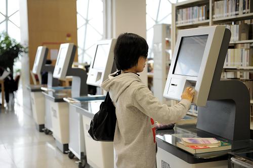 一位市民在使用深圳圖書館的自助借還書系統(tǒng)借閱書籍(2月16日攝)。新華社記者 梁旭 攝