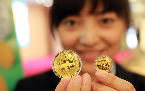 3月30日,中國金幣總公司的工作人員在中國熊貓金幣發(fā)行30周年發(fā)布會上展示1盎司和1/10盎司圓形金質(zhì)紀念幣。中國人民銀行3月30日發(fā)行“中國熊貓金幣發(fā)行30周年金銀紀念幣”一套。該套紀念幣共5枚,其中金幣3枚,分別為5盎司、1盎司和1/10盎司,銀幣2枚,分別為5盎司和1/4盎司。5枚紀念幣均為中華人民共和國法定貨幣。該套金銀紀念幣正面圖案均為北京天壇祈年殿,并刊國名、年號及“中國熊貓金幣發(fā)行三十周年紀念”中文字樣。 新華社發(fā)(陳曉根 攝)