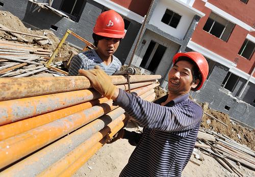 在寧夏銀川盈北家園保障性住房建設(shè)工地上,工人們?cè)诎徇\(yùn)建材(7月5日攝)。新華社記者 彭昭之 攝