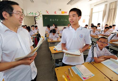 9月5日,就讀于福建省晉江市第一中學(xué)高一五班的重慶籍外來工子女田偉(中)在課堂上回答老師的提問。新華社記者 張國俊 攝