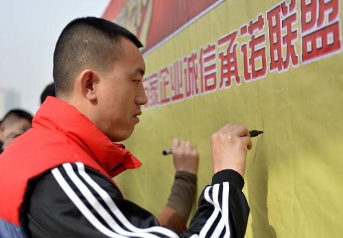 3月15日,在呼和浩特市萬(wàn)達(dá)廣場(chǎng),一名商家代表在“萬(wàn)家企業(yè)誠(chéng)信承諾聯(lián)盟”墻上簽名。新華社記者 任軍川攝