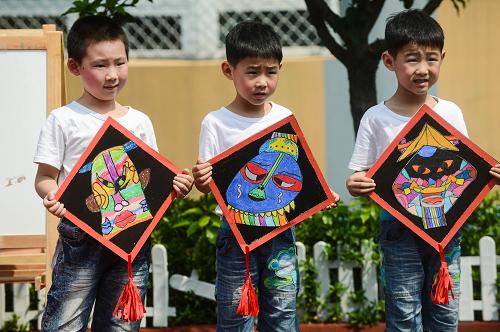 5月21日,孩子們在展示自己畫的臉譜。新華社記者 徐昱 攝