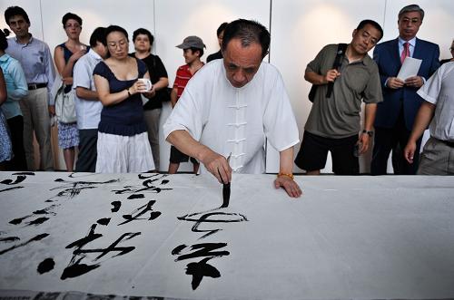 2011年8月18日,在瑞士日內(nèi)瓦萬國宮舉行的“墨韻中國”陳金純書法展開幕式上,書法家陳金純現(xiàn)場(chǎng)表演書法。 中國傳統(tǒng)的書法、飲食、舞蹈、電影、歷史,甚至獨(dú)特的語言,在瑞士人的眼中都是充滿魅力的東方符號(hào)。近年來隨著各界文化交流活動(dòng)的增多,這些無形的大使為瑞士人描摹了一個(gè)越來越清晰生動(dòng)的中國,也在兩國人心中架起友誼的橋梁。 新華社記者于洋攝