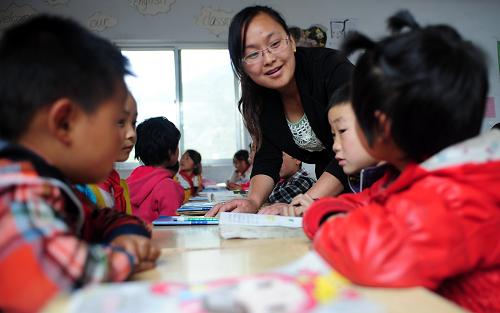 5月27日,在甘肅省宕昌縣何家堡中心小學的跨越式教學實驗課上,一名教師在指導學生們進行拓展閱讀訓練。新華社記者 張錳 攝