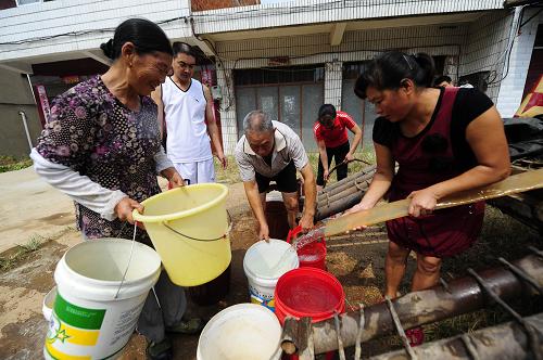 8月16日,隨州市隨縣萬福店鎮(zhèn)黑龍口村的村民圍著送水車接水。新華社記者 郝同前 攝