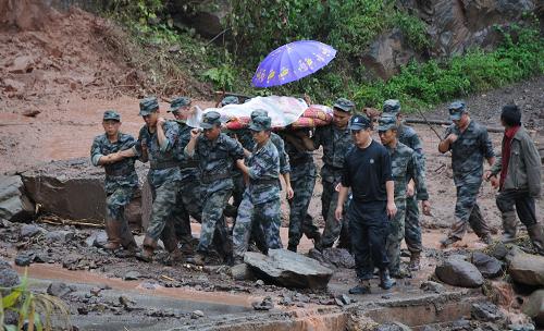 9月11日,彝良縣彝海公路晏家灣一處滑坡地段上,成都軍區(qū)某炮兵旅官兵緊急轉(zhuǎn)運(yùn)一名重傷婦女到醫(yī)院。 新華社記者 閆起磊 攝