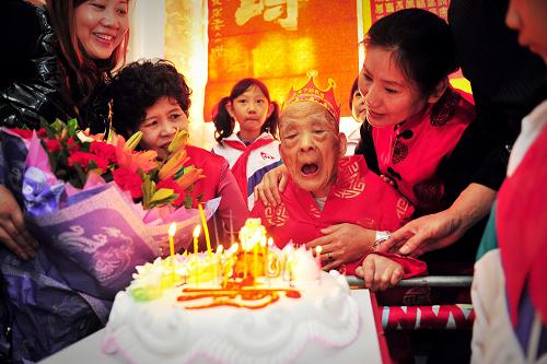 10月22日,葉至孝老人在家人和社區(qū)志愿者的簇?fù)硐?,?zhǔn)備吹熄生日蛋糕上的蠟燭。10月23日是重陽節(jié),對于天津市和平區(qū)綿陽道社區(qū)的葉至孝老人來說,更是意義非凡——這一天是他的百歲生日。在22日為他提前舉辦的祝壽會上,社區(qū)志愿者與和平中心小學(xué)的師生們?yōu)樗蜕硝r花、蛋糕和《百壽圖》,向他表達(dá)誠摯的祝福。