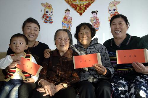文登市西樓社區(qū)99歲老人孫月璞(左三)的子女及其配偶每人領(lǐng)取到5000元孝老金(10月22日攝)。為弘揚養(yǎng)老、愛老、敬老風(fēng)氣,山東省文登市西樓社區(qū)居委會自2010年起為轄區(qū)高壽老人的子女發(fā)放孝老金,凡父母年齡達到90周歲,其子女及其配偶每年可領(lǐng)取1000元孝老金;95周歲以上孝老金為5000元;100周歲以上為2萬元。據(jù)悉,截至2011年,西樓社區(qū)居委會已發(fā)放孝老金20萬元。
