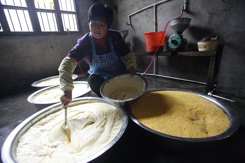 10月22日,農(nóng)民譚美鳳采用傳統(tǒng)方式對玉米漿調(diào)料發(fā)酵。湖北省五峰土家族自治縣灣潭鎮(zhèn)龍橋村農(nóng)民譚美鳳,發(fā)現(xiàn)城里人喜歡食用土家山寨的玉米餅,于是她于2007年秋按規(guī)章辦理了相關(guān)生產(chǎn)許可手續(xù),在自家辦起玉米餅加工作坊。開工后的首批玉米餅還沒運出灣潭鎮(zhèn)即被一搶而空,后來日產(chǎn)量從幾百個慢慢漲到上萬個,但始終都由她一人手工制造。她的玉米餅作坊臨近湖北325省道,采用電話預(yù)定的售賣方式,將包裝好的玉米餅通過過往車輛,發(fā)送到北京、上海、深圳、武漢、宜昌等地。在她的帶動下當(dāng)?shù)赜钟?0多個農(nóng)戶辦起家庭玉米餅加工作坊,可謂“小小玉米餅,創(chuàng)出大市場”。