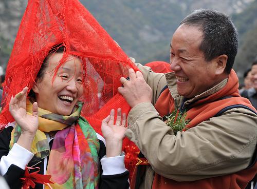 10月23日,王老漢(右)為自己的老伴揭蓋頭,重溫當(dāng)年幸福浪漫。當(dāng)日是中國(guó)傳統(tǒng)節(jié)日重陽(yáng)節(jié),陜西旅游集團(tuán)公司少華山管理局在景區(qū)內(nèi)為陜西的99對(duì)金、銀婚老人舉辦“金銀婚老人重溫當(dāng)年幸福浪漫”活動(dòng) ,通過揭蓋頭、飲交杯酒及攜手并肩登山等活動(dòng)讓老人重溫當(dāng)年的浪漫時(shí)光。