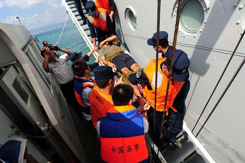 10月24日,一名受傷的漁民被抬上前來迎接的海事局的船只。10月23日21時25分,一艘前往三沙開展作業(yè)的“瓊瓊海09039”漁船在三亞偏東方向約90海里處沉沒,船上16名漁民全部落水遇險。海南省海上搜救中心立即組織救助,協(xié)調(diào)“南海救198”輪、海軍“863”艦、“SUPA BHUM”輪(泰國籍)、“WAN HAI 275”輪(新加坡籍)等船只前往救助。24日6時48分,遇險的16名漁民全部獲救,獲救后漁民乘坐海軍“863”艦返回三亞港。24日13時45分,在三亞海事局以及搜救、漁政等部門的幫助下,16名漁民全部轉(zhuǎn)移上岸,均無生命危險。