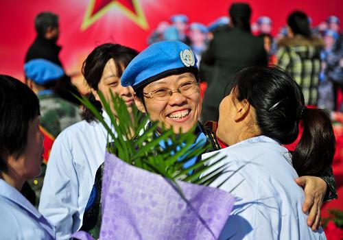 11月13日,一位維和部隊(duì)醫(yī)療分隊(duì)的隊(duì)員(右二)與同事?lián)肀Ц鎰e。新華社記者 張超群 攝